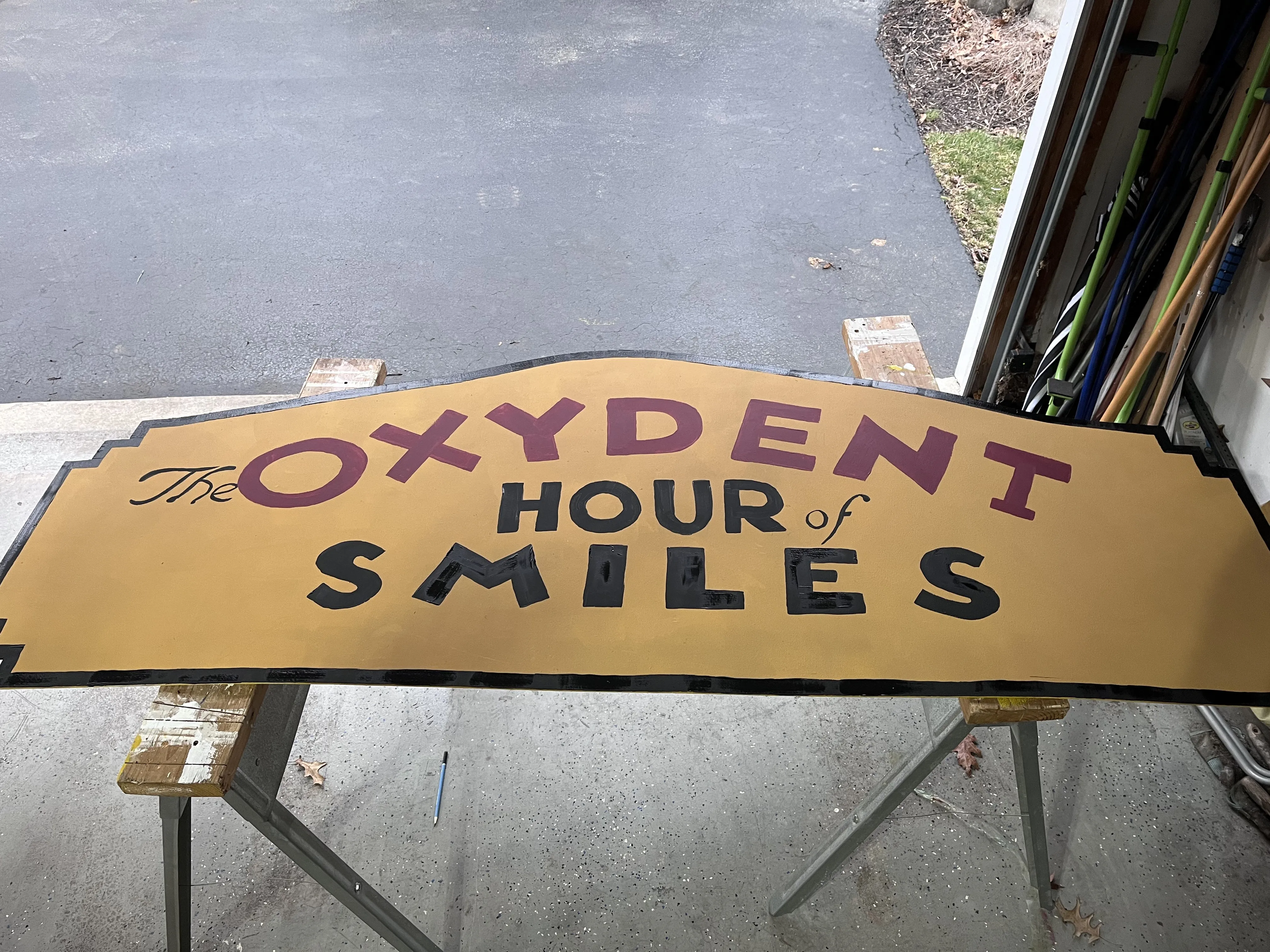 The Oxydent Hour of Smiles sign being painted in the driveway