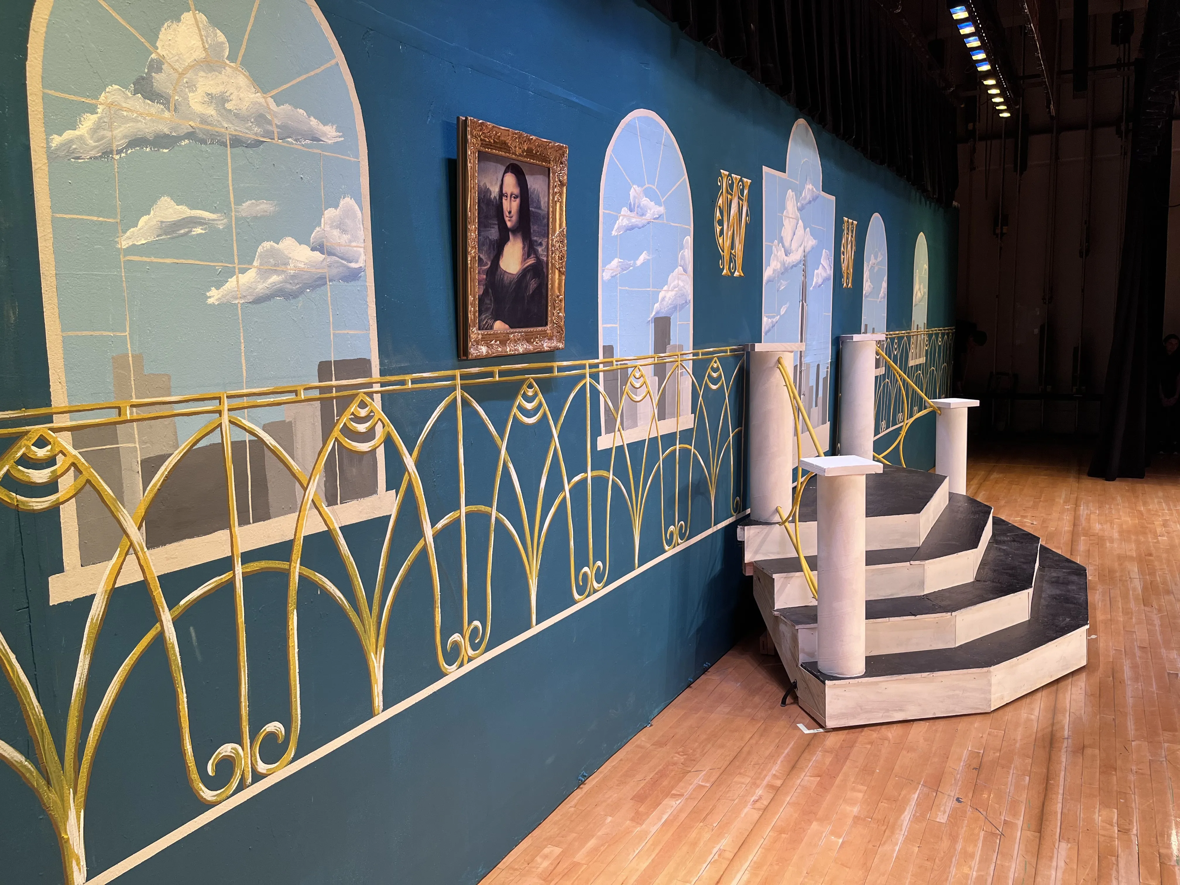 The Warbucks backdrop side view with the Mona Lisa hung on the wall and the staircase at right