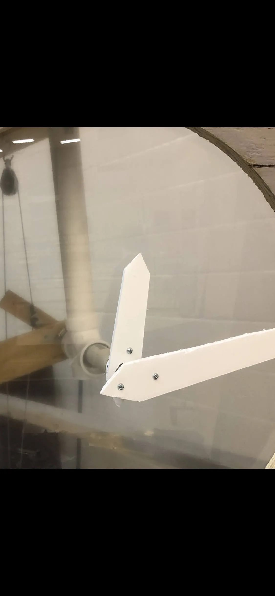The two white clock hands mounted on the PVC pivot