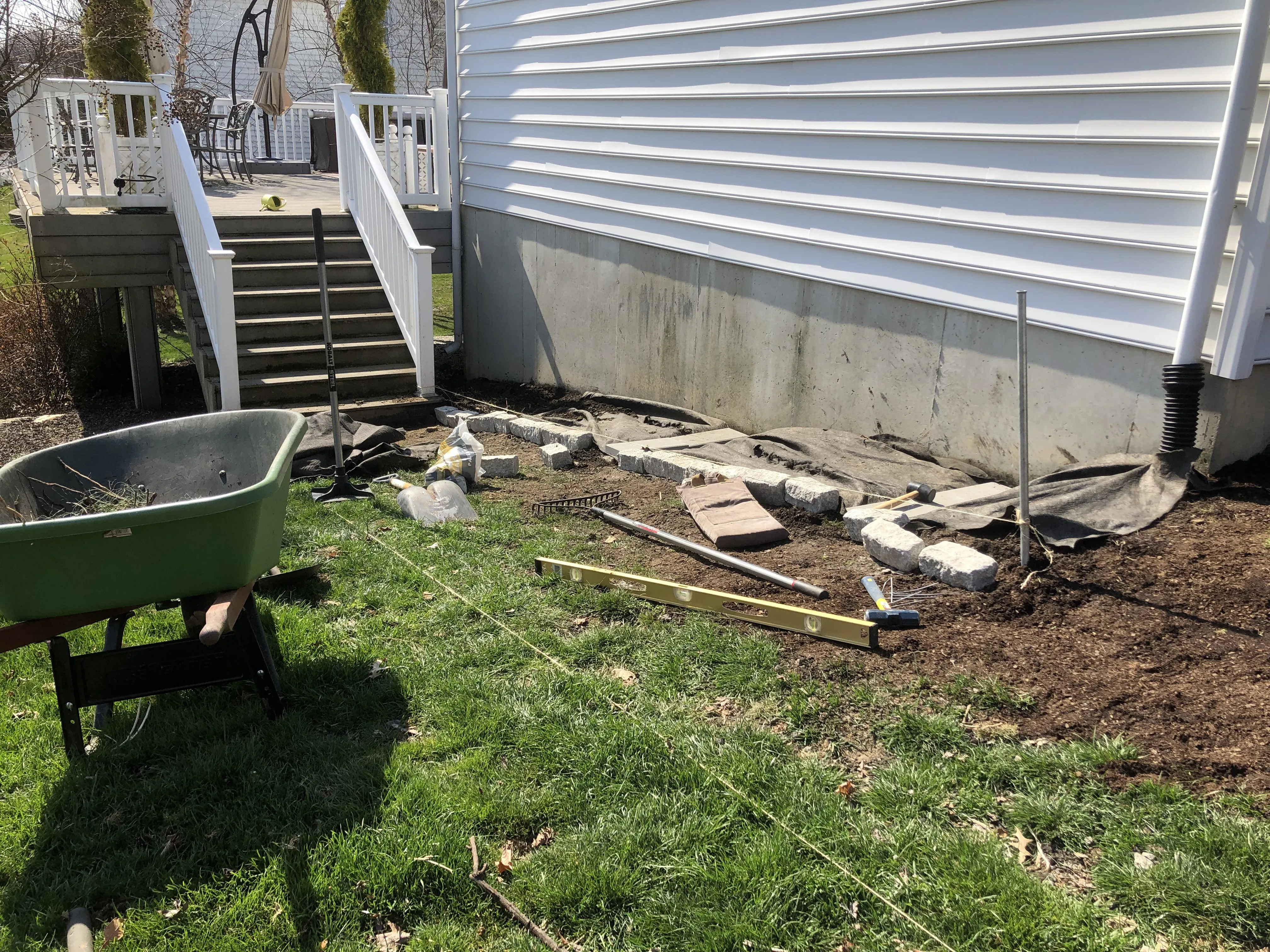 Mid-build — landscape fabric down, pavers going in, beds starting to take shape