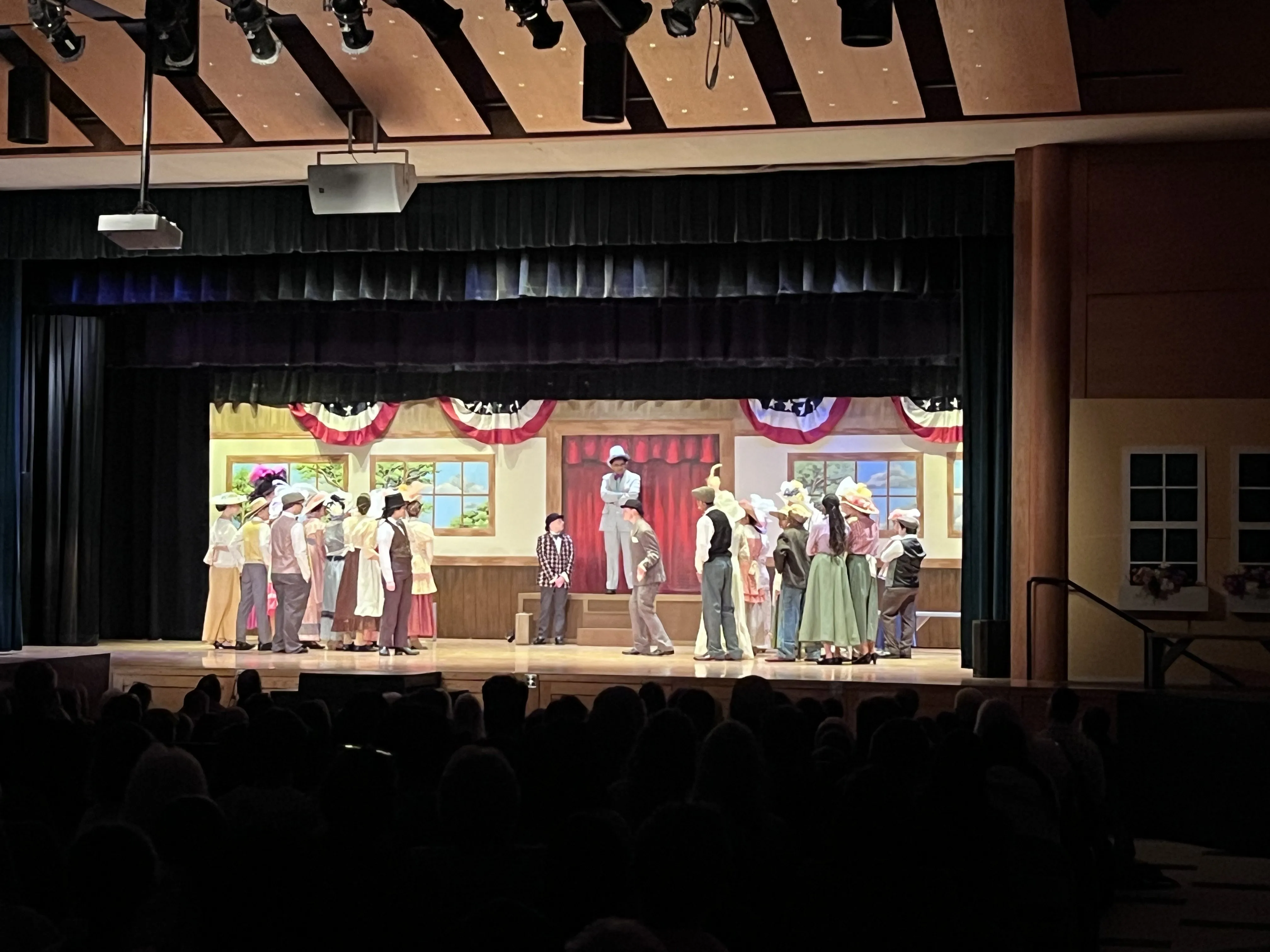Harold Hill on the platform, full cast gathered around him for the town scene