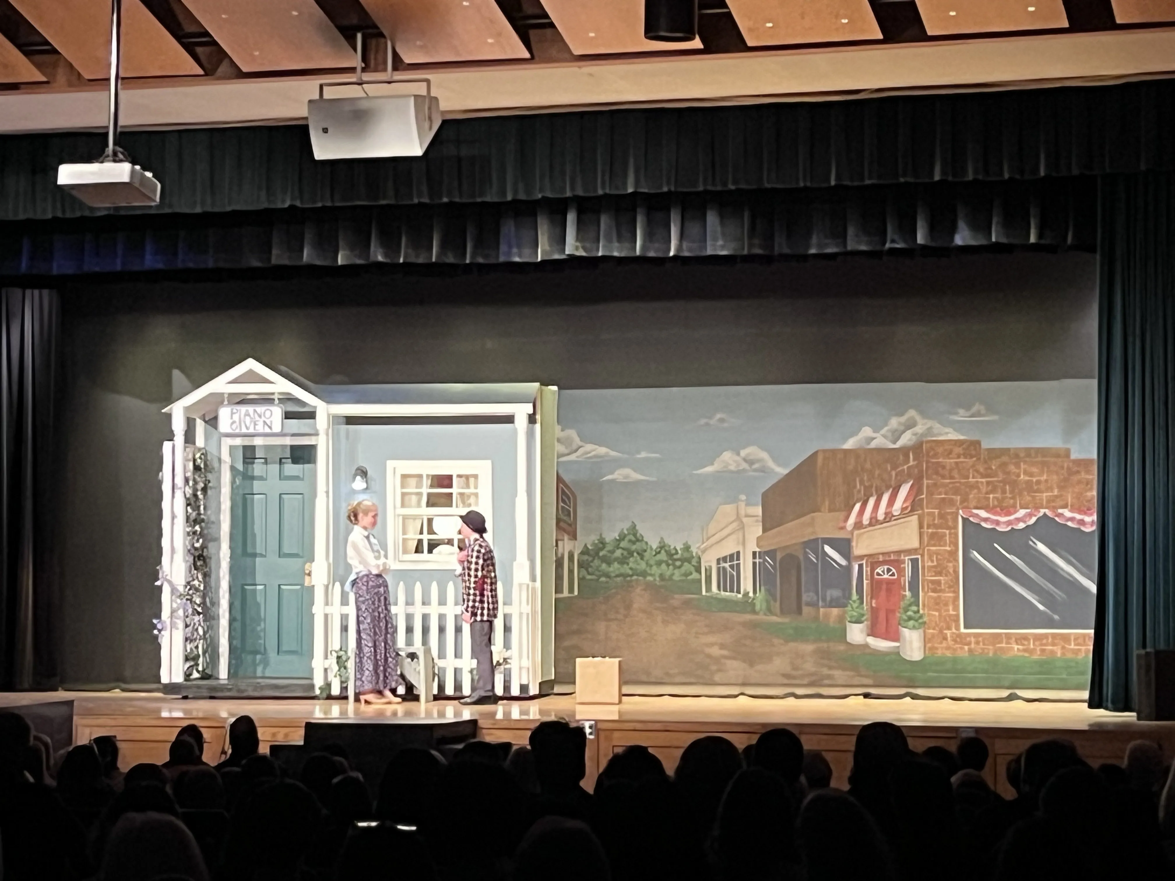 Marian and Harold Hill at the house — the house flat on stage with the River City painted backdrop behind it