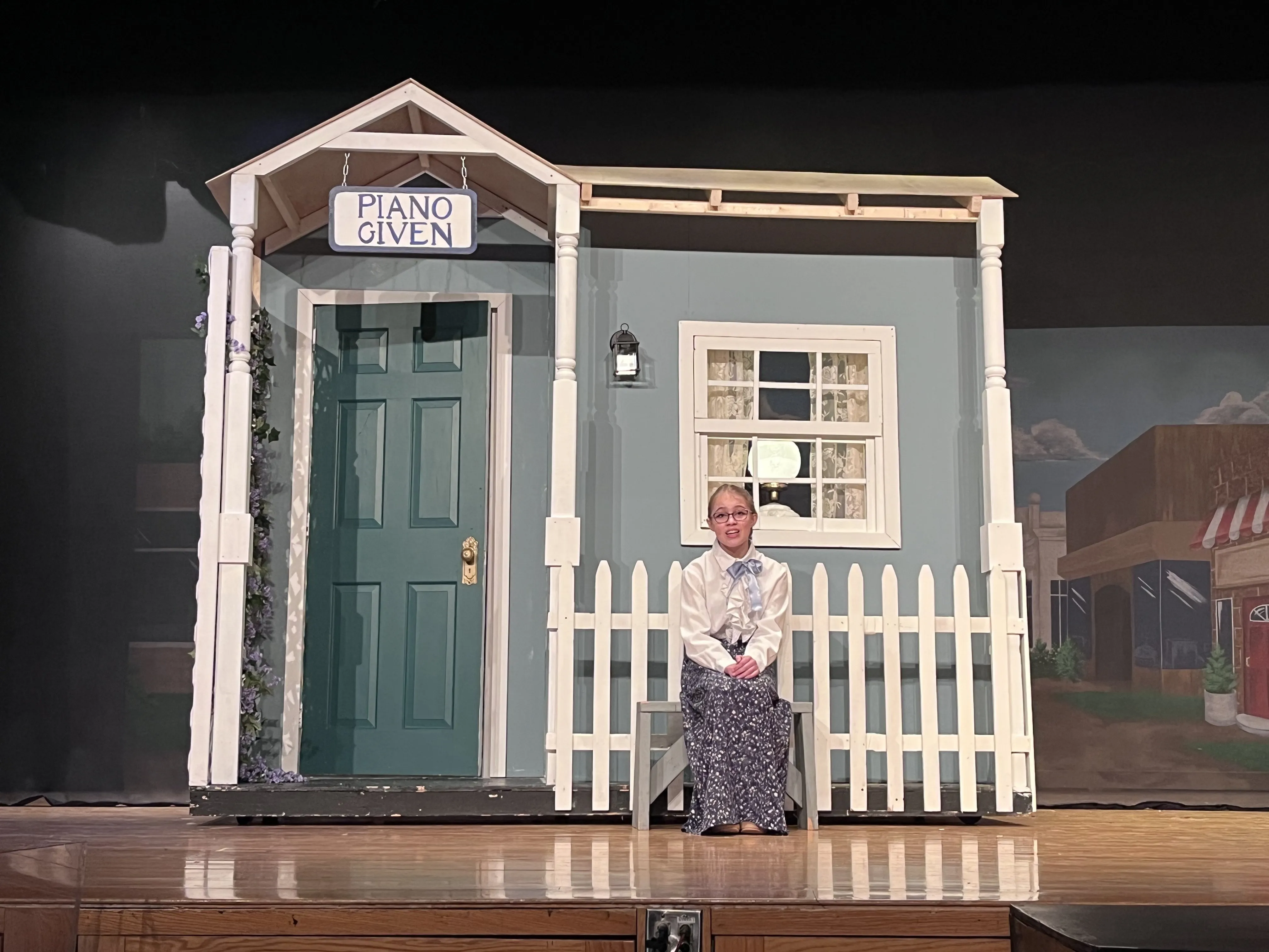 Marian seated in front of her house during the performance